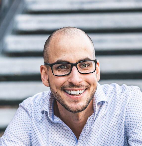 Tobias Franek im Portrait vor einer Metallstiege