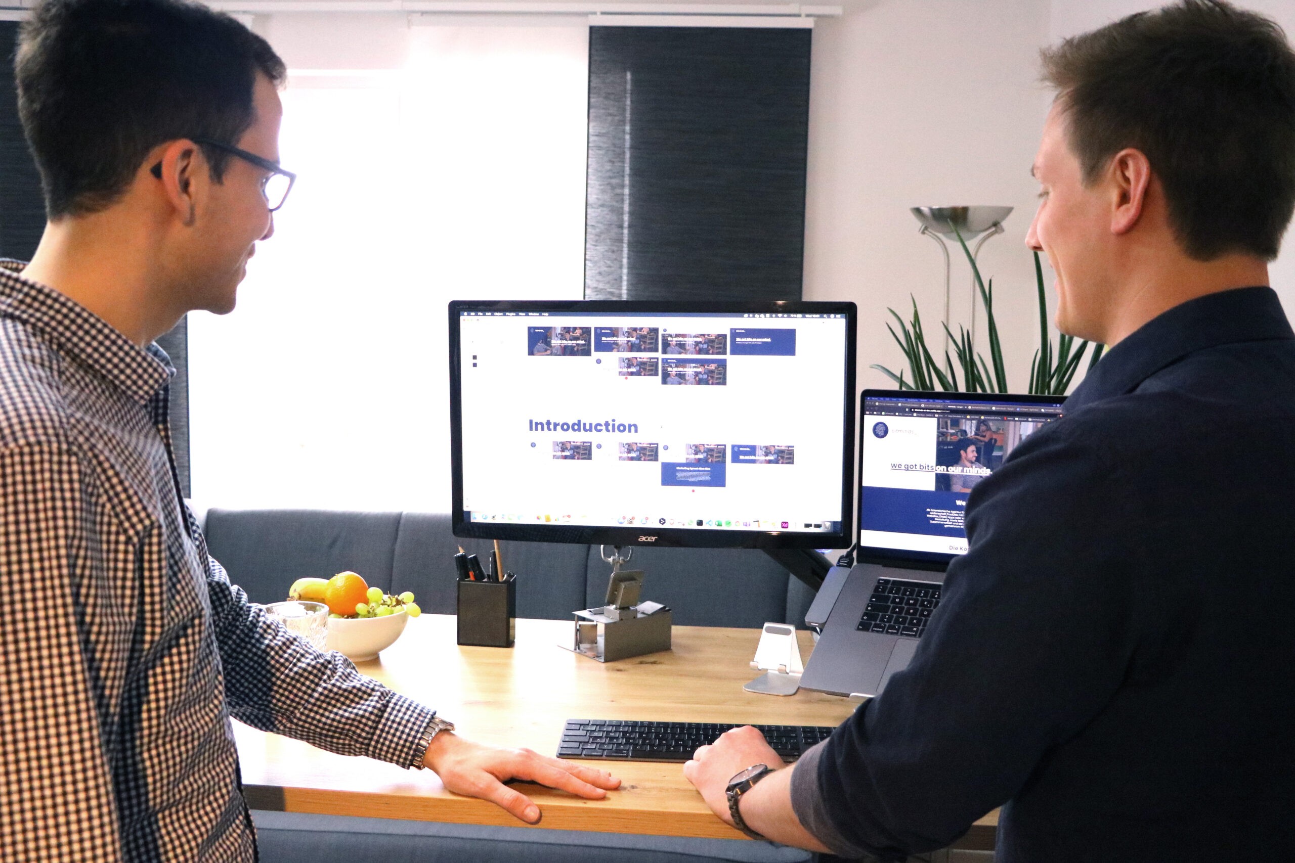 Thomas Steiner und Tobias Franek vor einem Computer auf dem ein Design geöffnet ist.